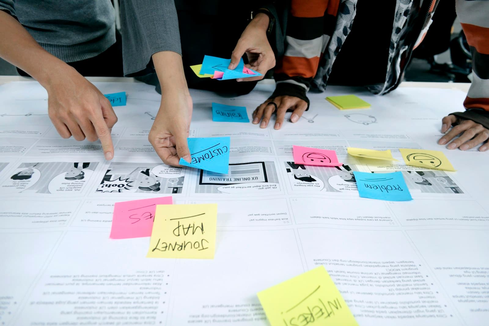 Hands arranging sticky notes while mapping out a solution