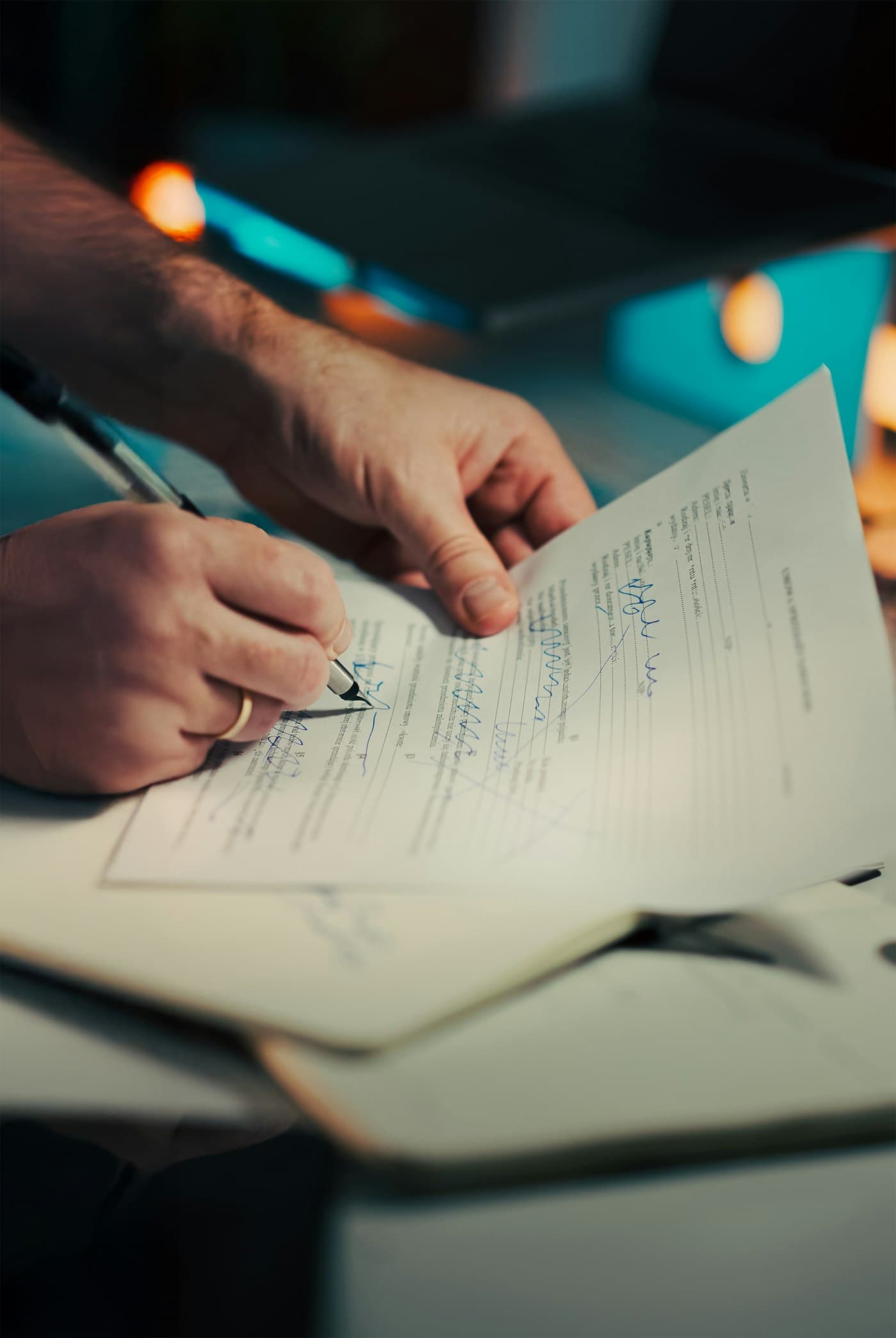 Close-up of hands signing an approval form with a pen